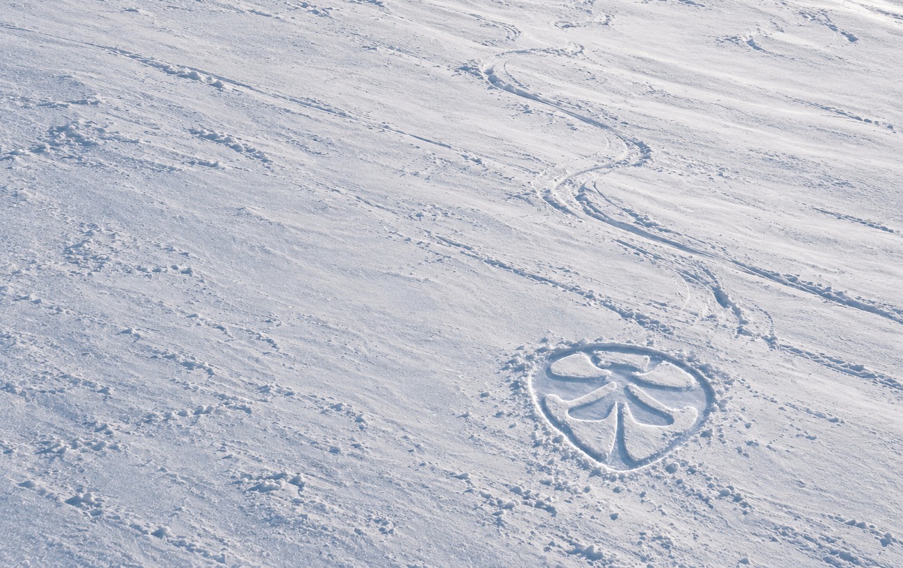 The same slope further down, with the SCORP mark pressed into the snow